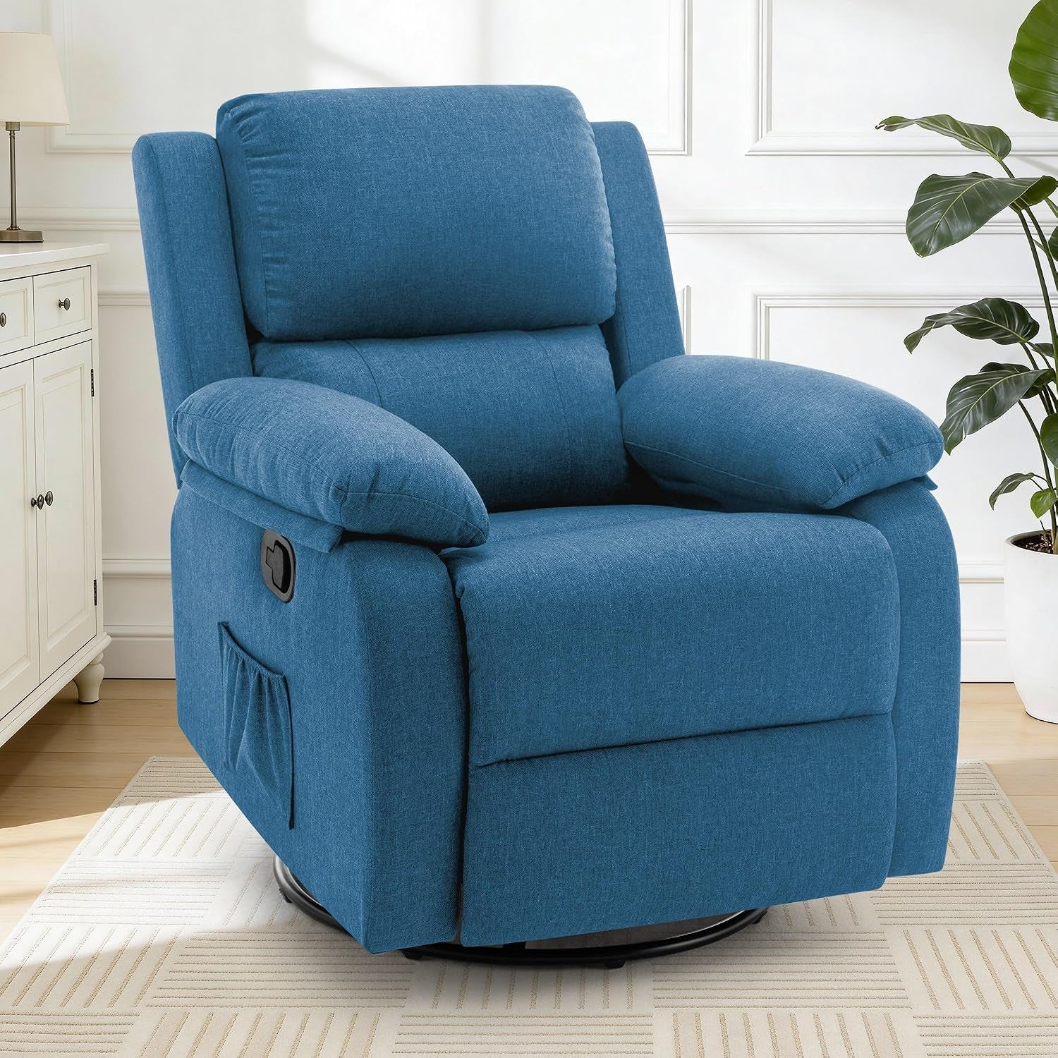 Blue fabric swivel recliner placed on a rug in a white room next to a cabinet and potted plant