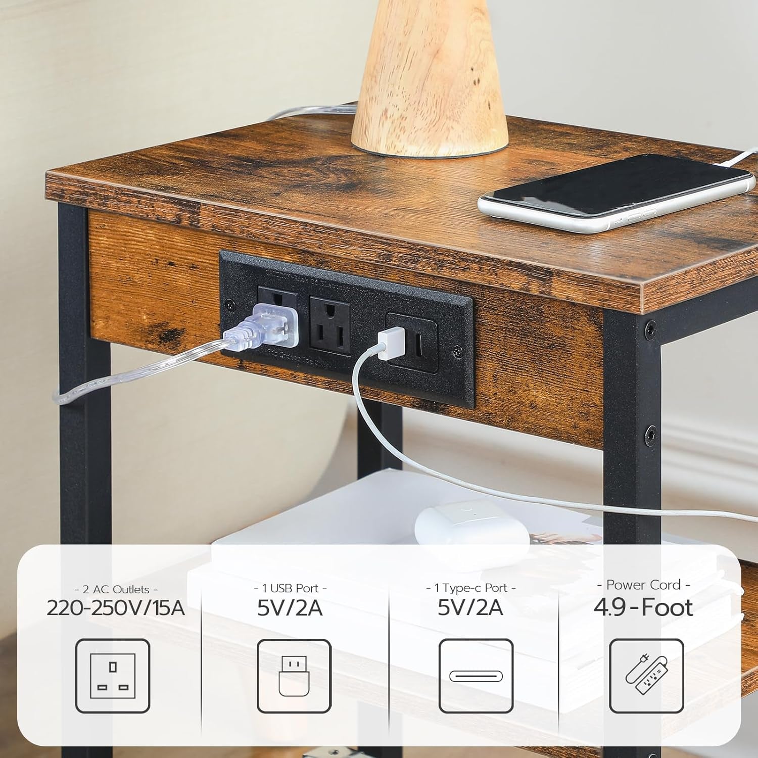 Close-up of charging panel on table front showing two AC outlets and a USB port with device cords connected