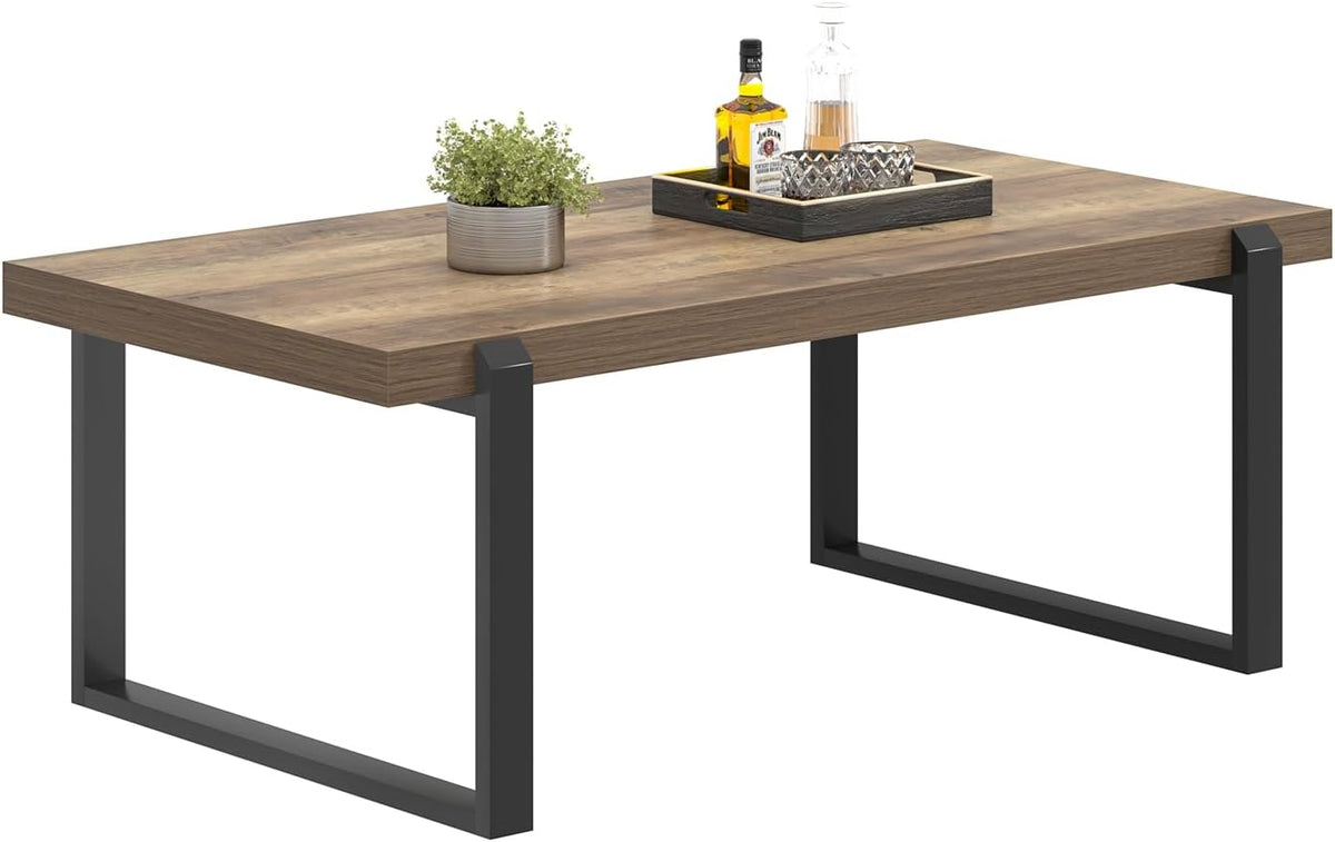 Studio view from front-right showing the tabletop edge, a small plant and tray, and the black U-shaped metal legs.