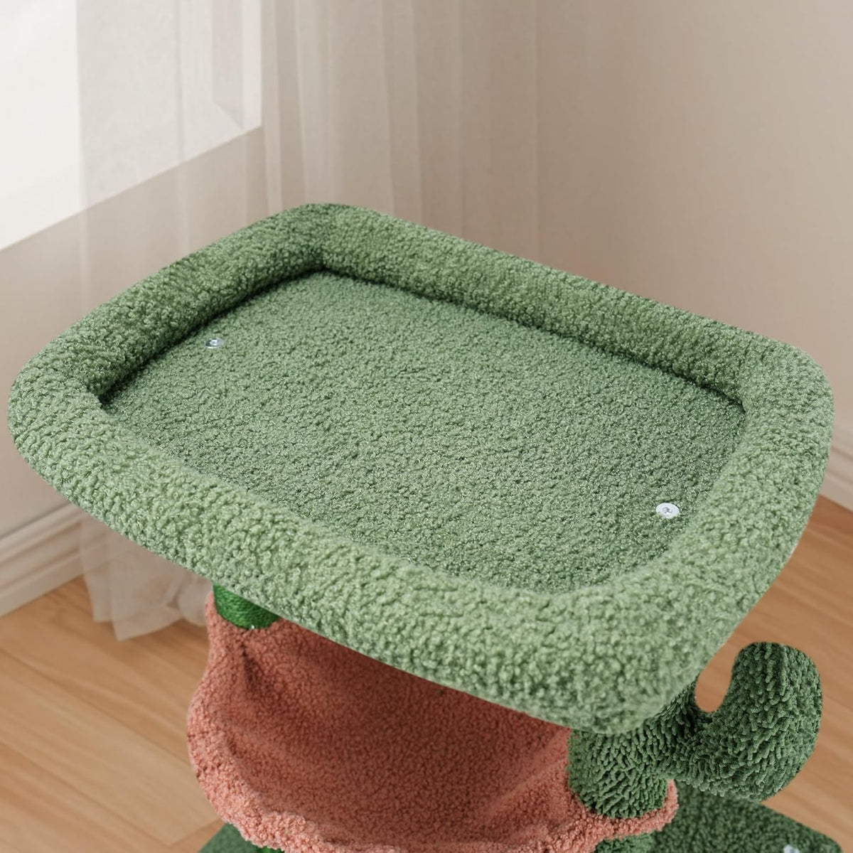 Close-up of the square green top perch with raised padded edges on the cat tree