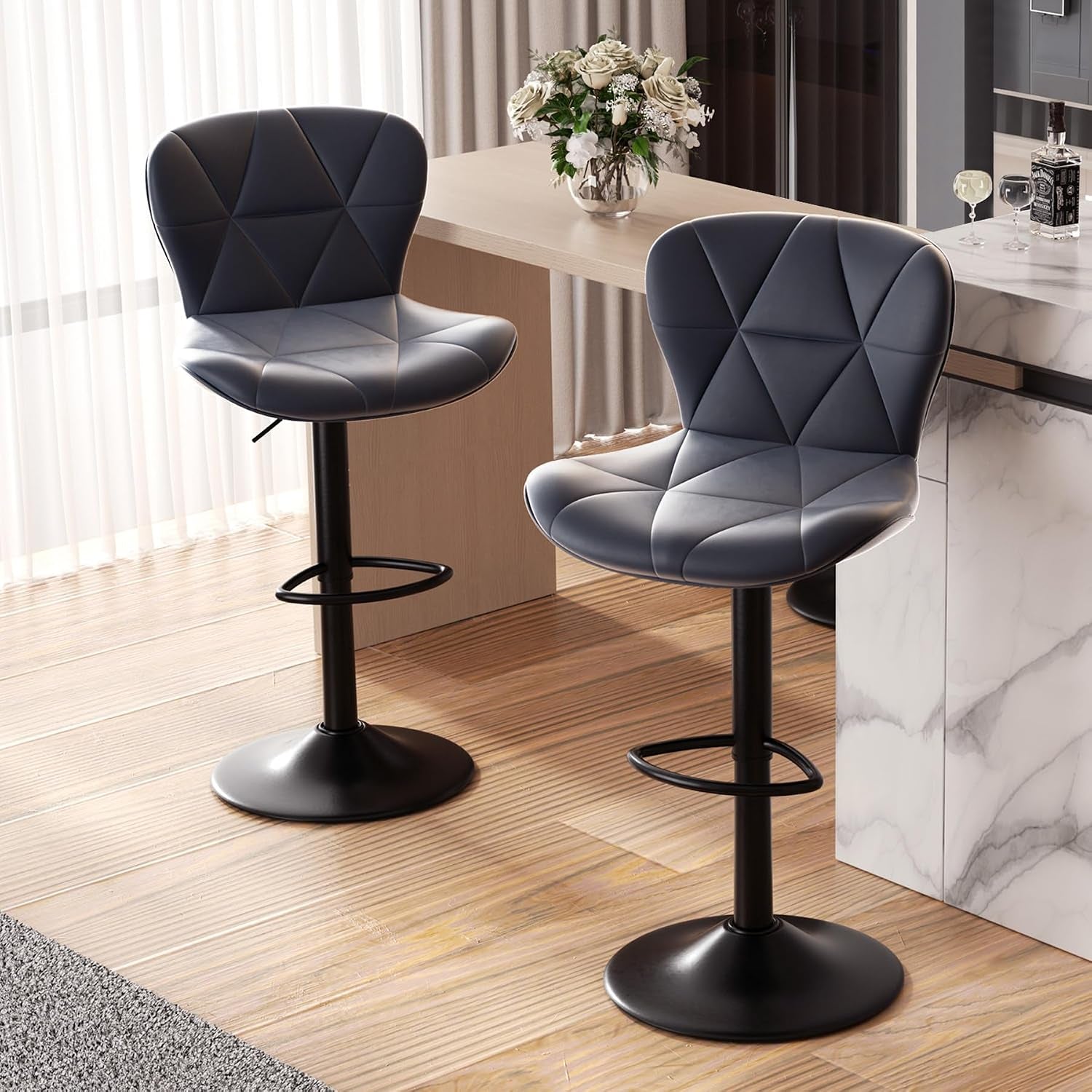 Two dark charcoal bar stools with quilted backs shown side-by-side beside a wood counter
