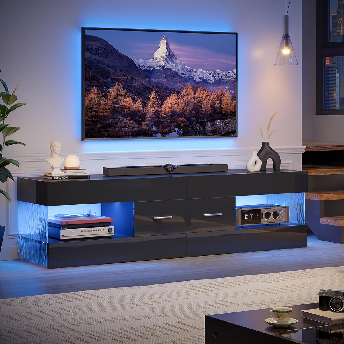 Black high-gloss TV stand with blue LED lighting viewed front in a modern living room setting