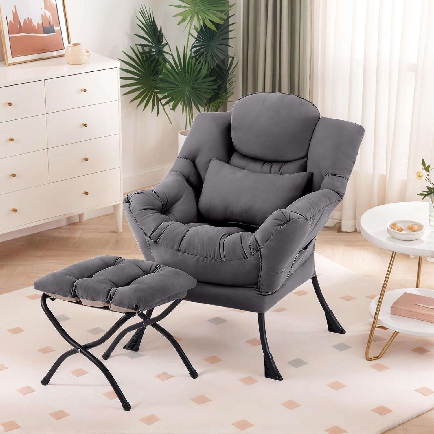 Gray padded lounge chair with matching ottoman in a bright living room by a white dresser