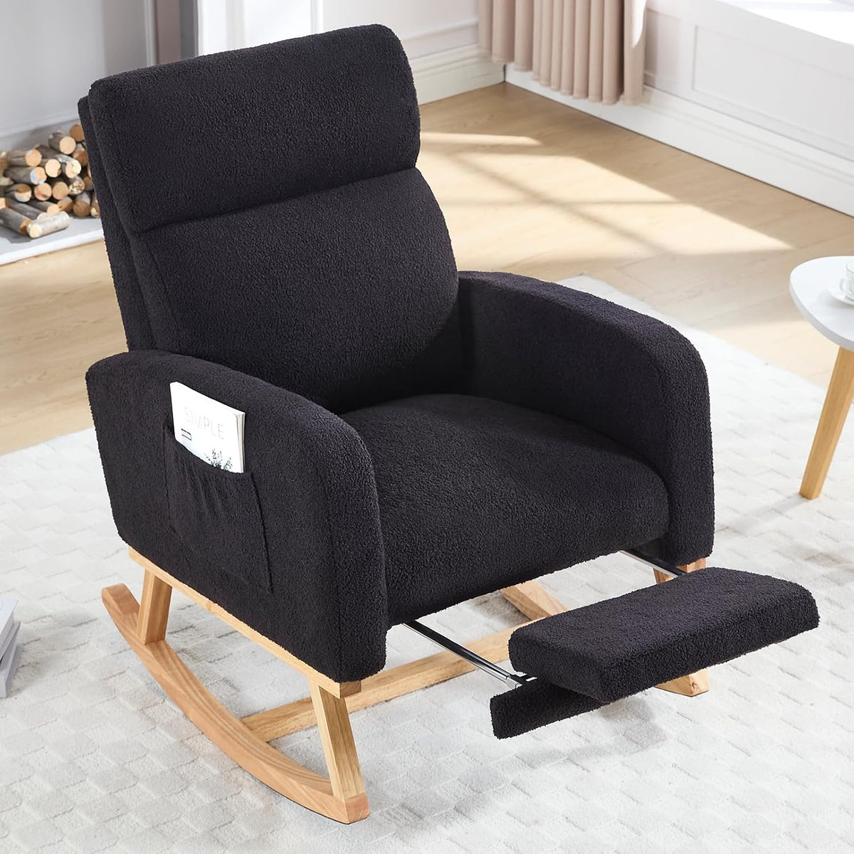 Black upholstered rocking chair with wooden rocker base and extended footrest, magazine in side pocket.