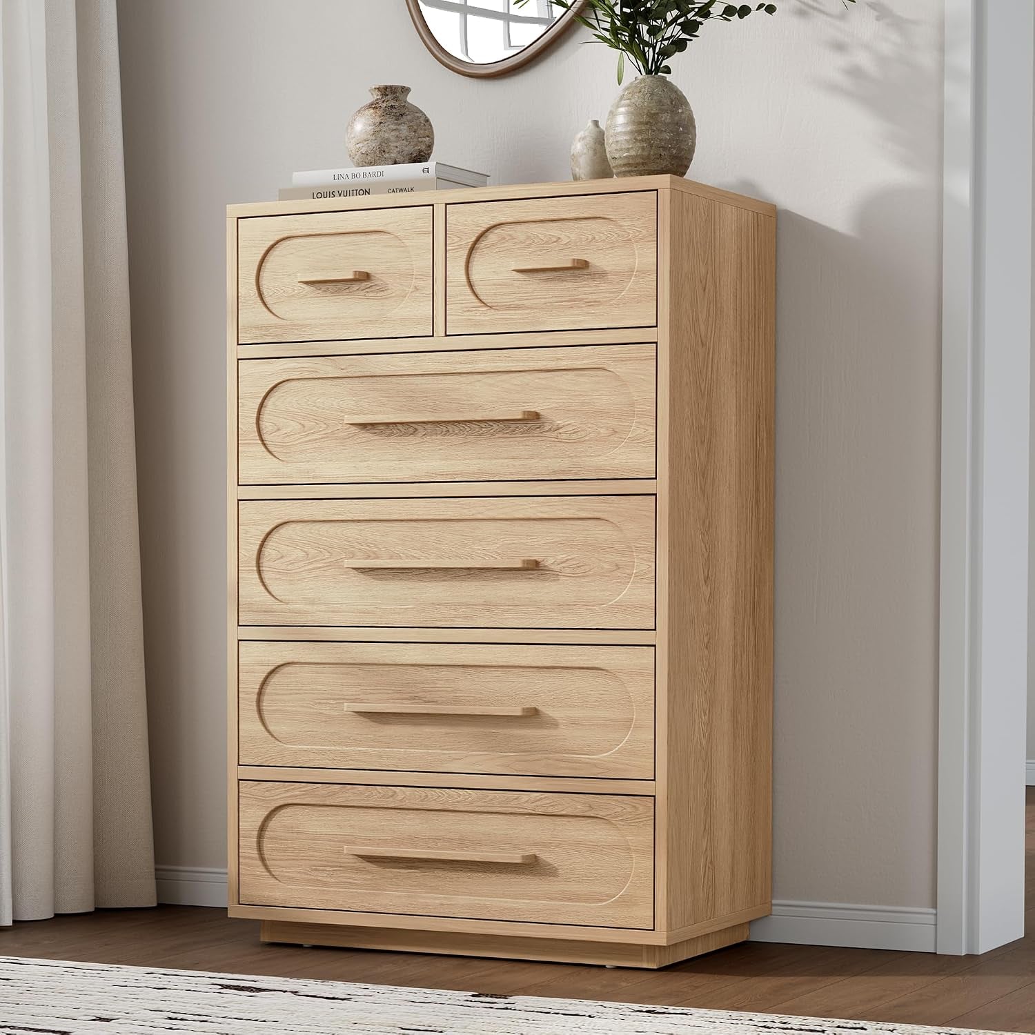 Tall light-oak chest of drawers standing beside a curtain with decorative vases on top