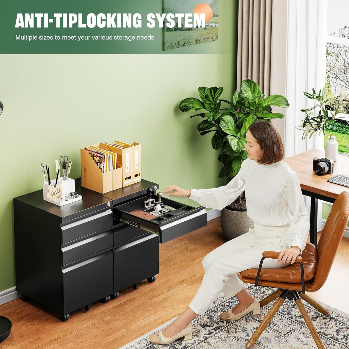 Woman seated at a desk opening the top drawer of a black mobile file cabinet