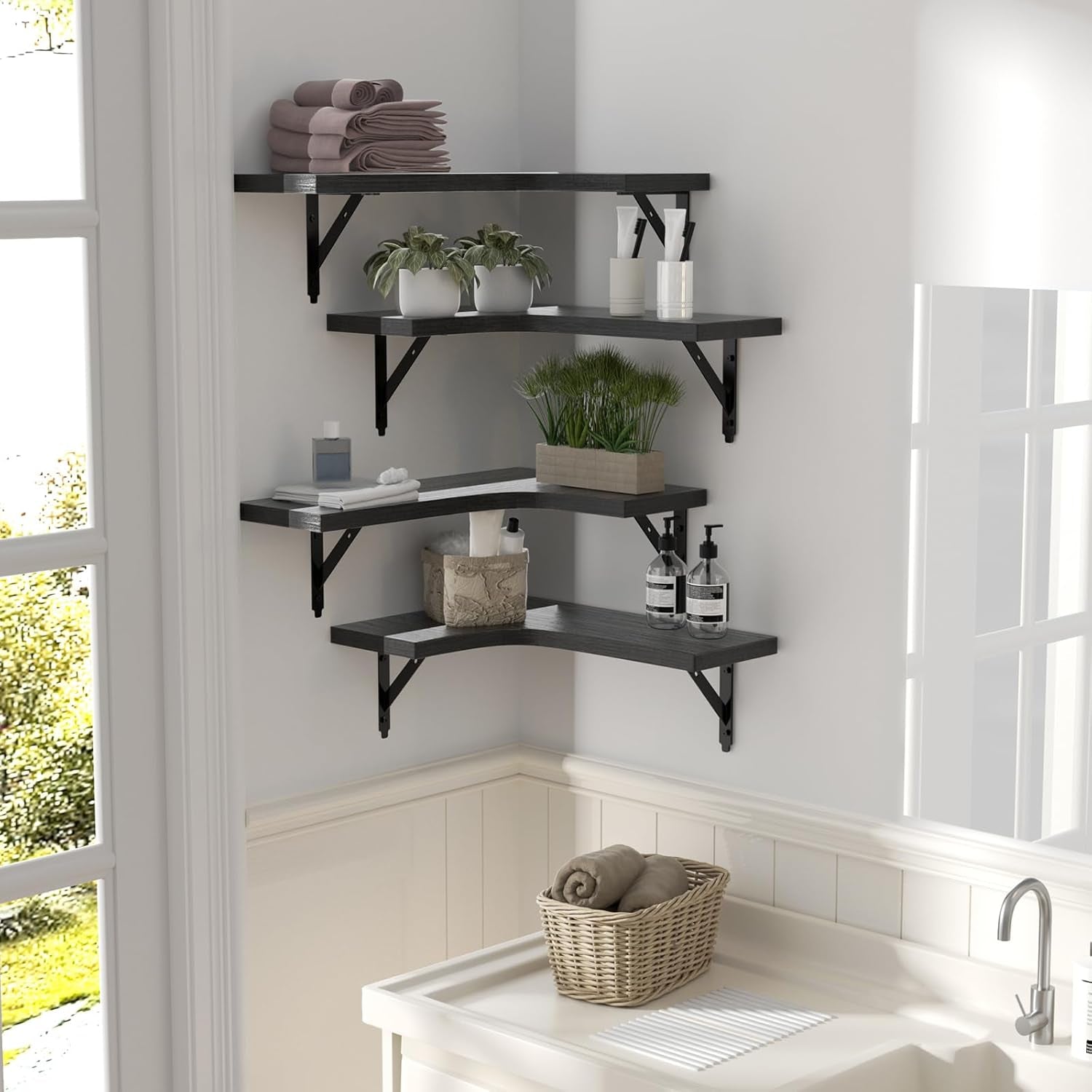 Black L-shaped shelves mounted in a bathroom corner holding towels and toiletries