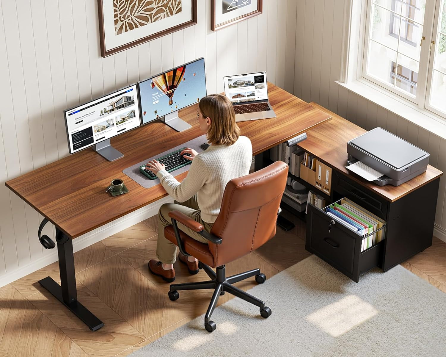 Overhead view of person seated at L-shaped walnut desk with dual monitors and an open file drawer