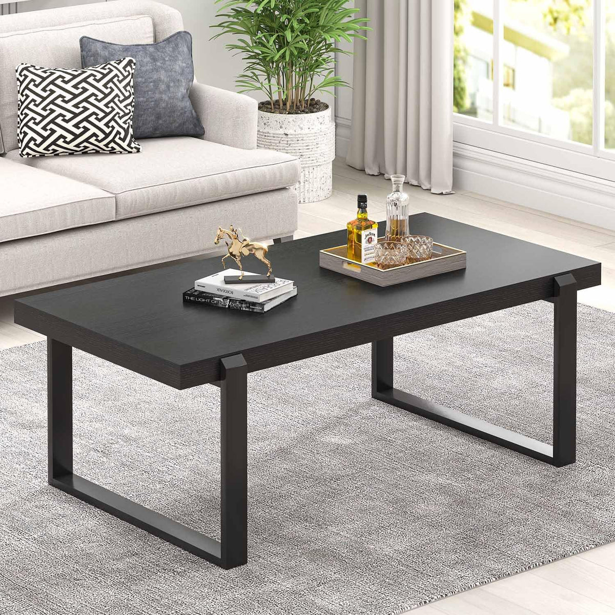Black rectangular tabletop with matching black U-shaped legs, styled with decorative tray and sculpture.