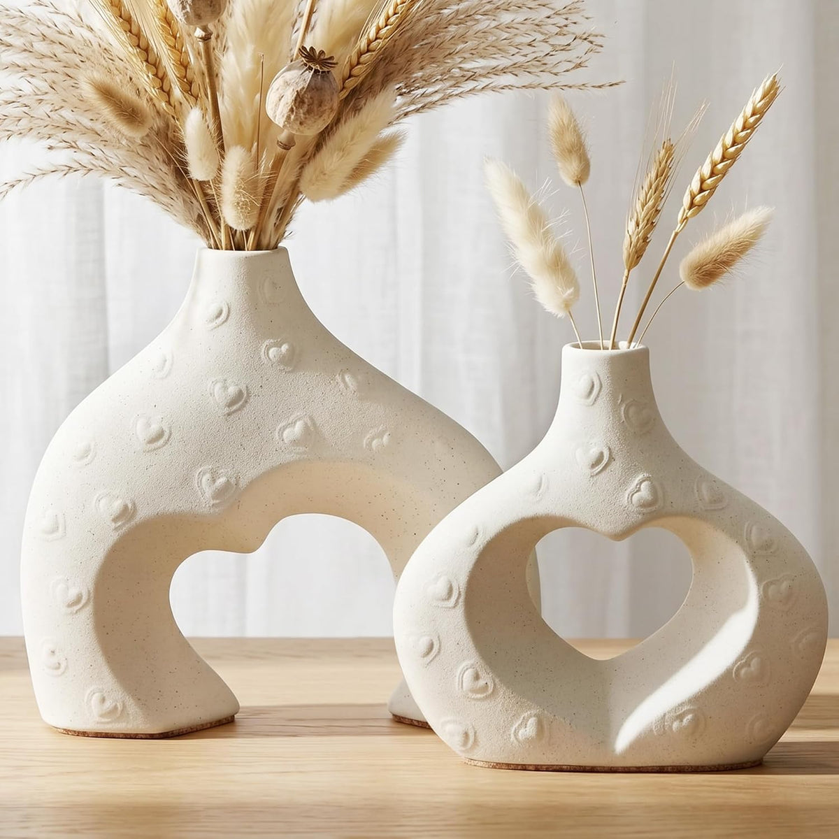 Front close-up of two cream vases showing small embossed heart texture and cork bases.