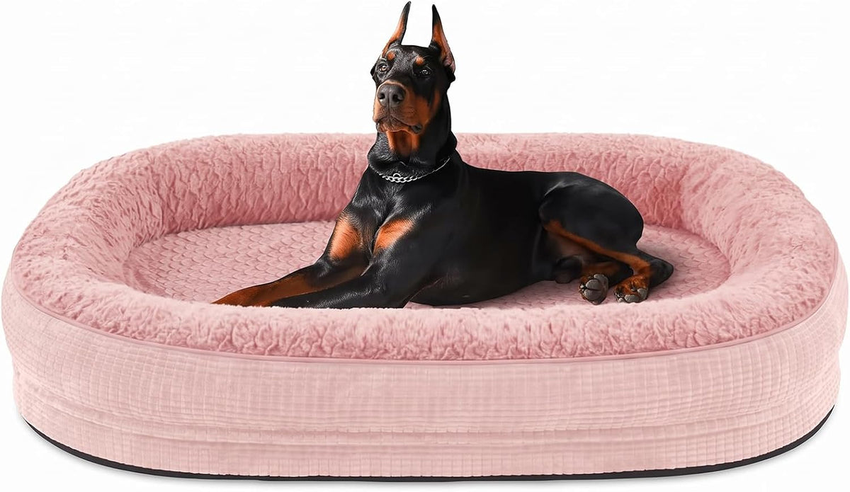 Doberman reclining inside a pink oval bolster dog bed, angled front view of textured fabric.