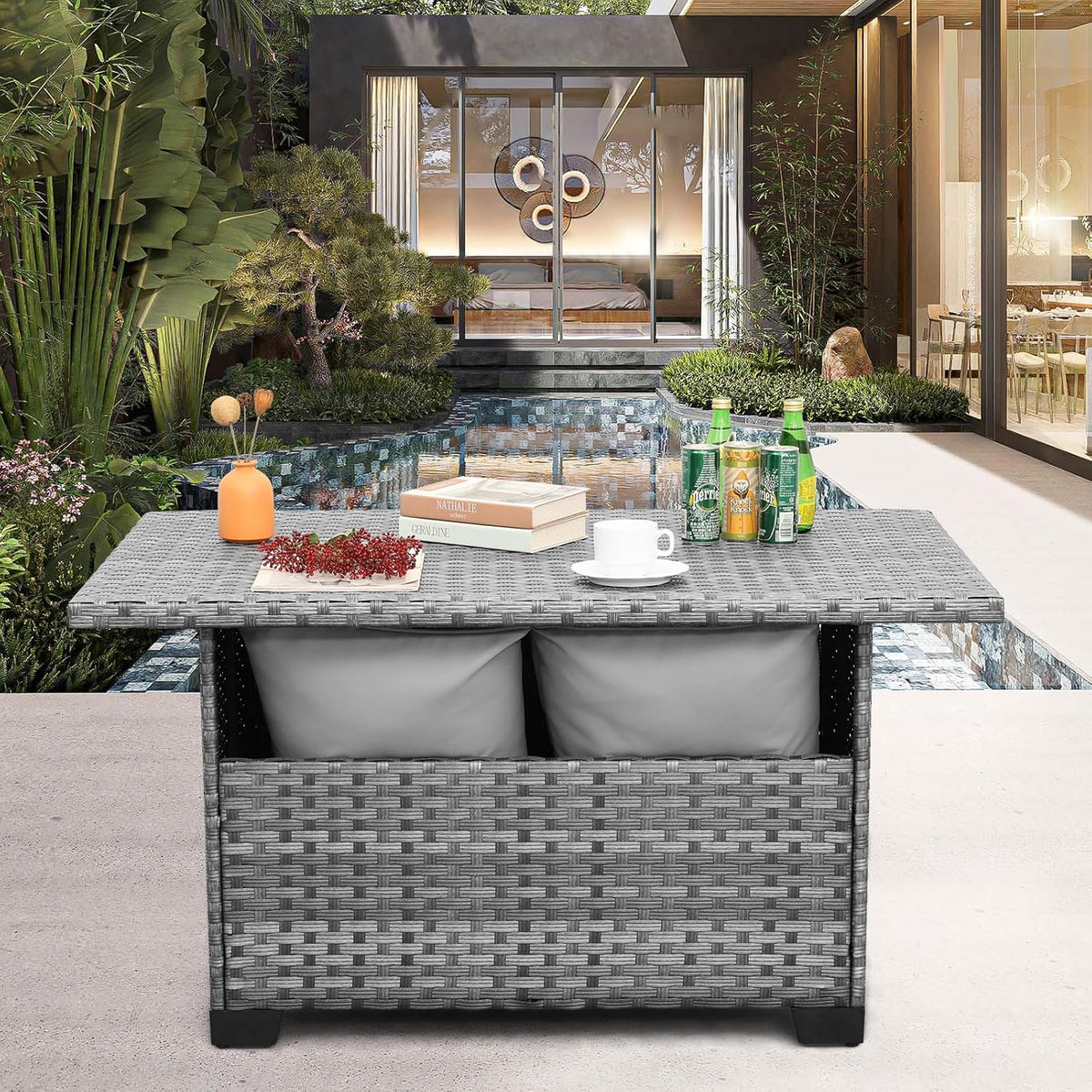 Grey wicker outdoor storage table front view with cushions inside storage and drinks on the tabletop near a pool