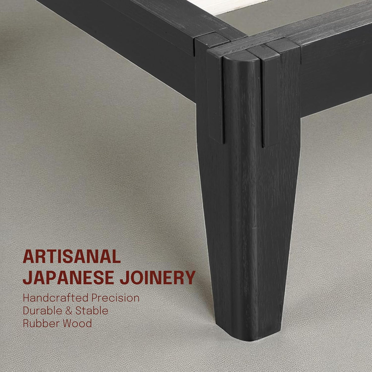 Close-up of a black wood bed corner showing mortise-and-tenon joint and tapered leg