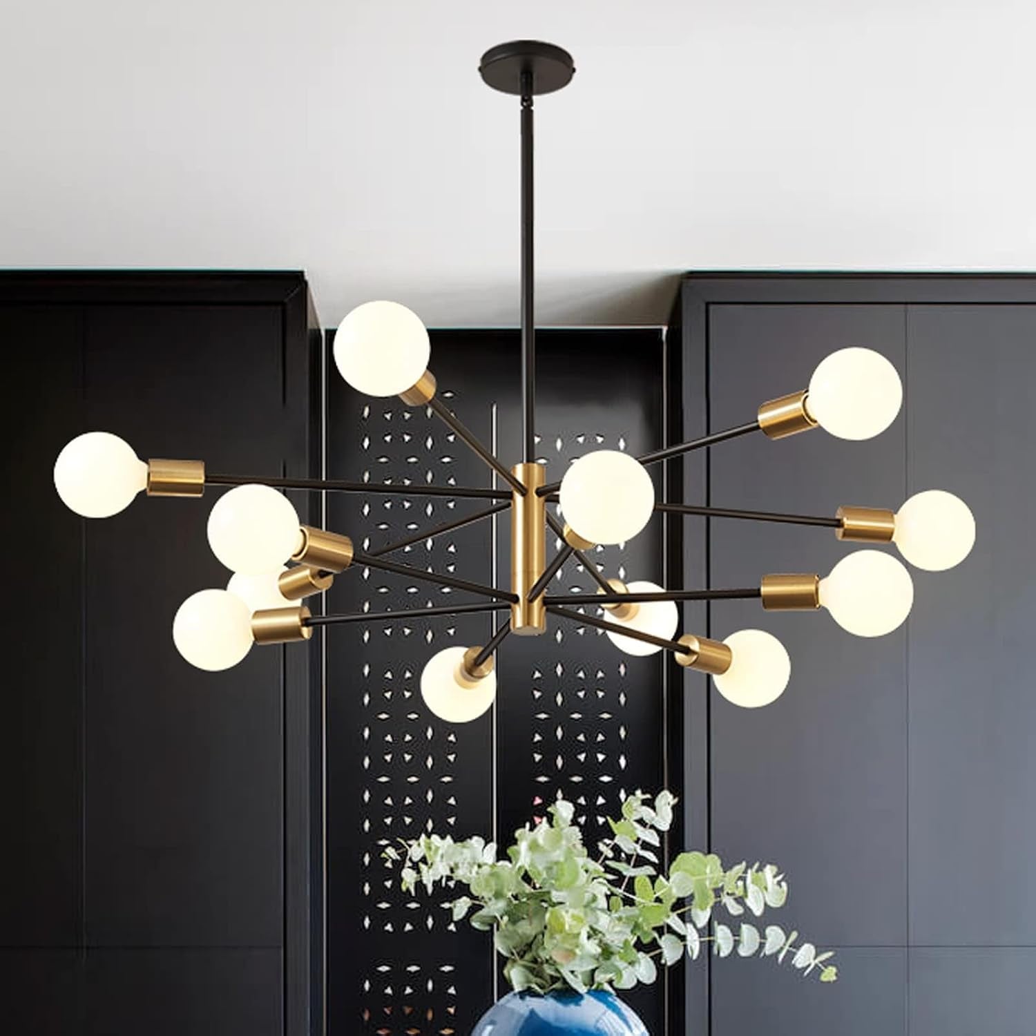 Two-tone sputnik chandelier over dark cabinets with a decorative vase on a table, centered view