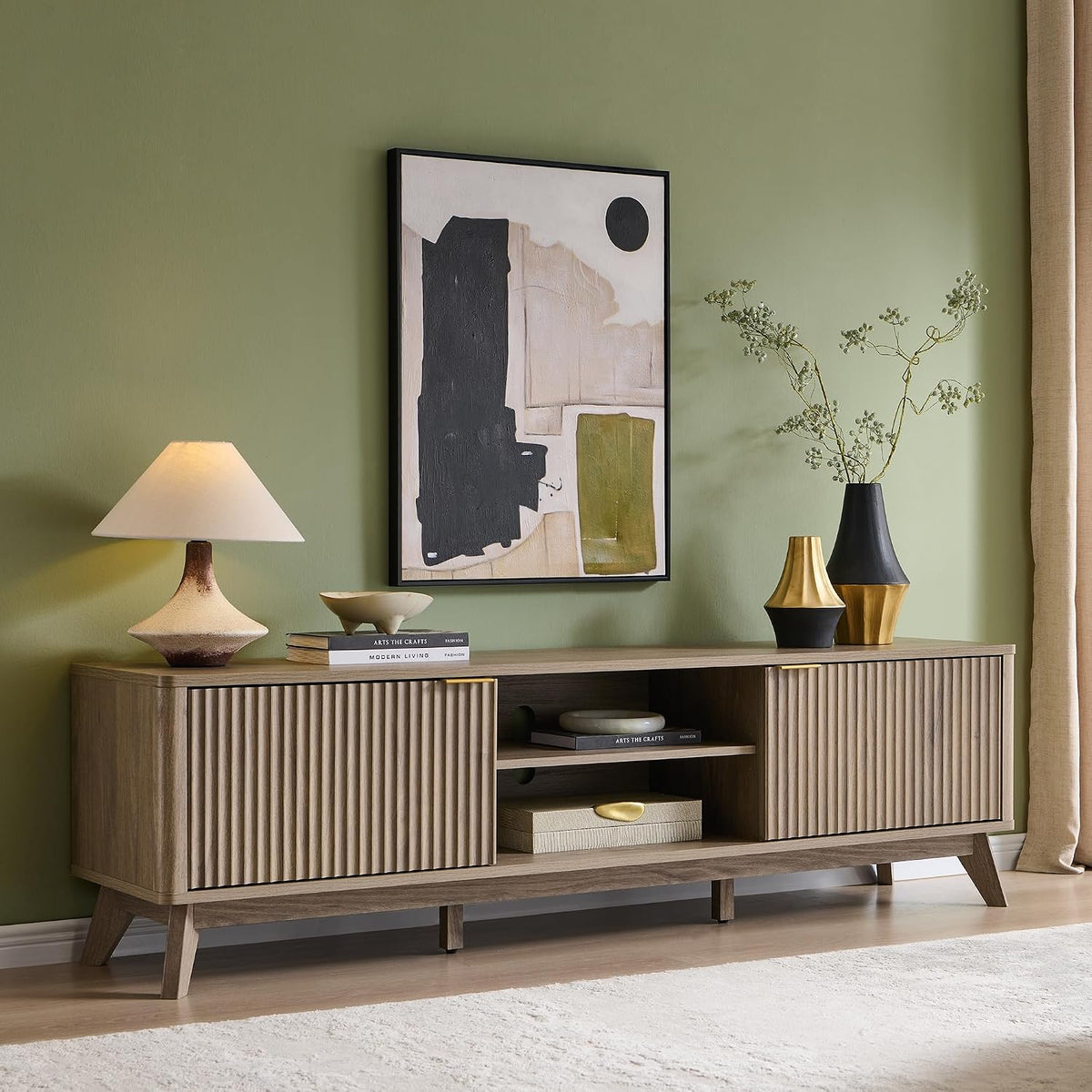 TV stand in a green-walled room with artwork and decorative vases on top.
