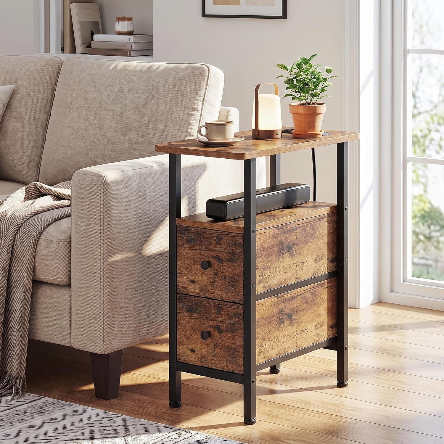 Narrow end table next to a sofa holding a lamp, plant and speaker with two closed drawers