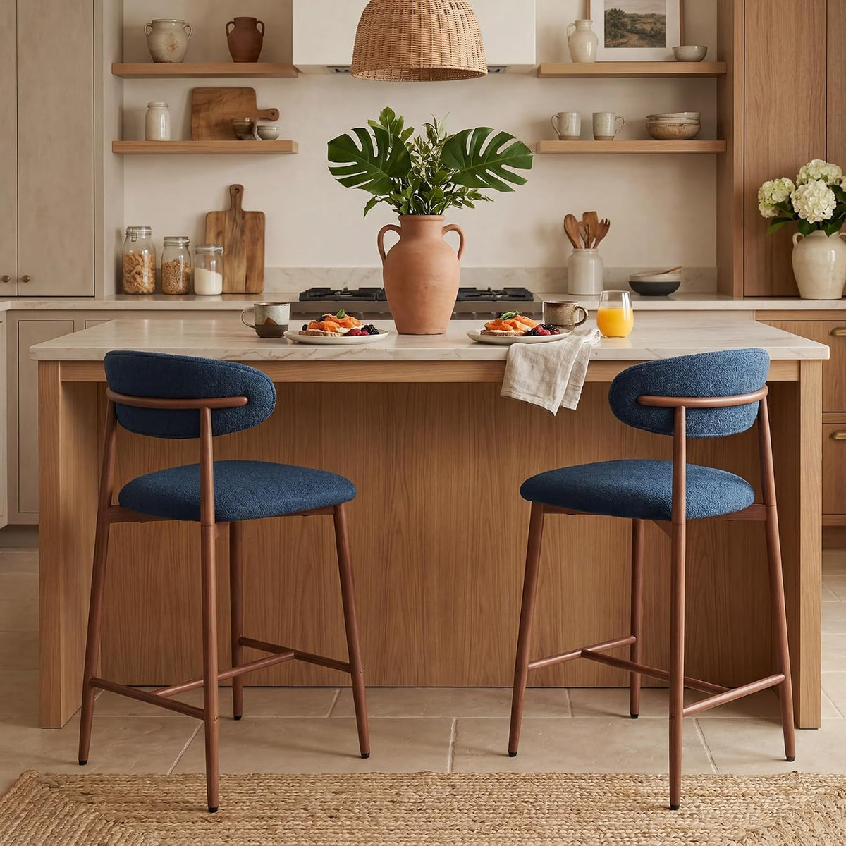 Two navy counter stools shown from behind at an island, highlighting rounded backs and tapered metal legs.