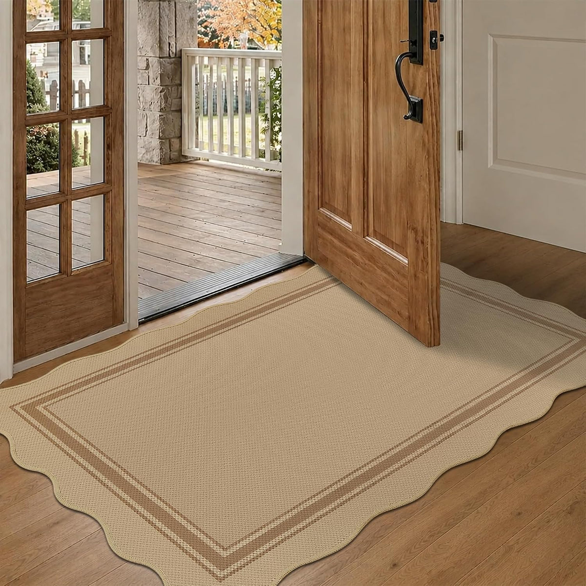 Entryway with a scalloped-edge beige rug laid on wood floor under an open wooden door