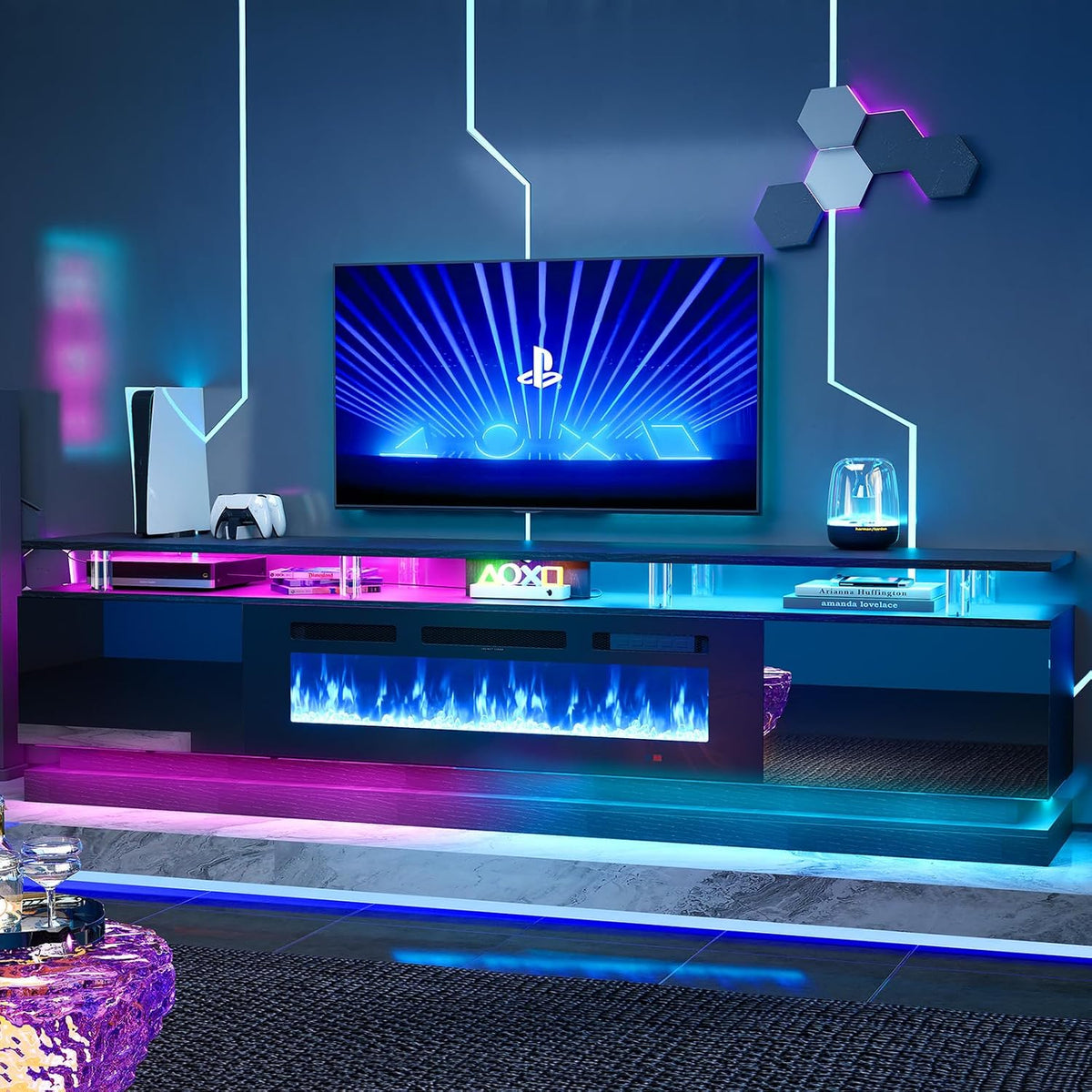 Dark-finish entertainment console with central glowing fireplace and illuminated open shelves beneath a mounted TV.