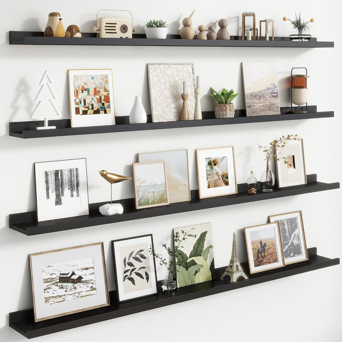 Three long black floating picture ledges mounted vertically with framed art and decor.