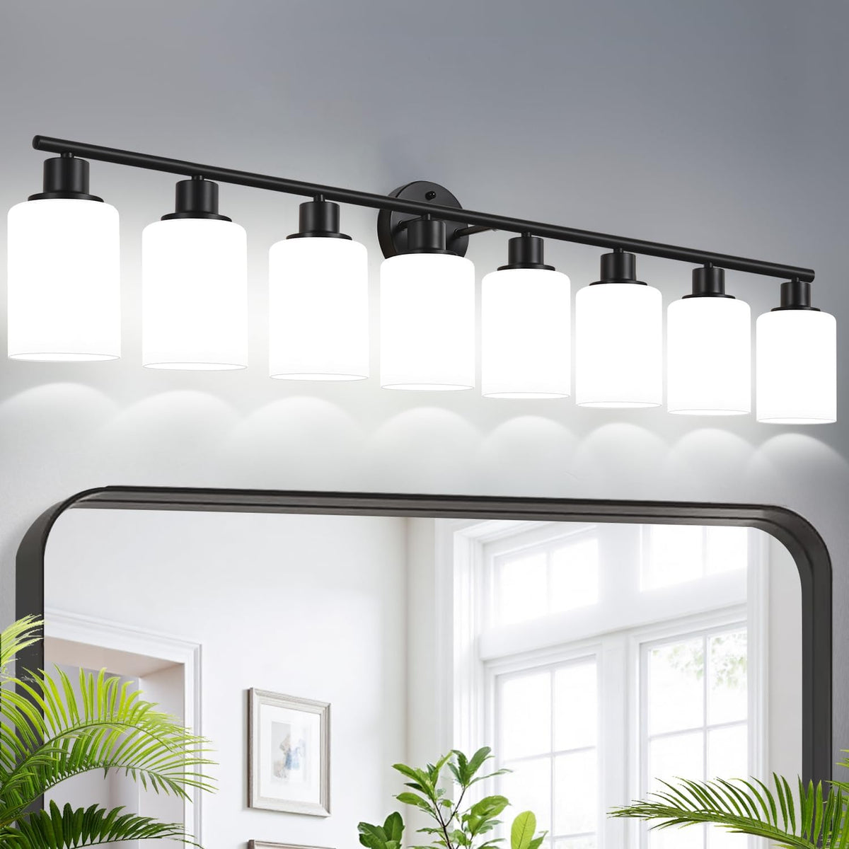 Black metal vanity light with seven cylindrical clear-glass shades mounted above a mirror.