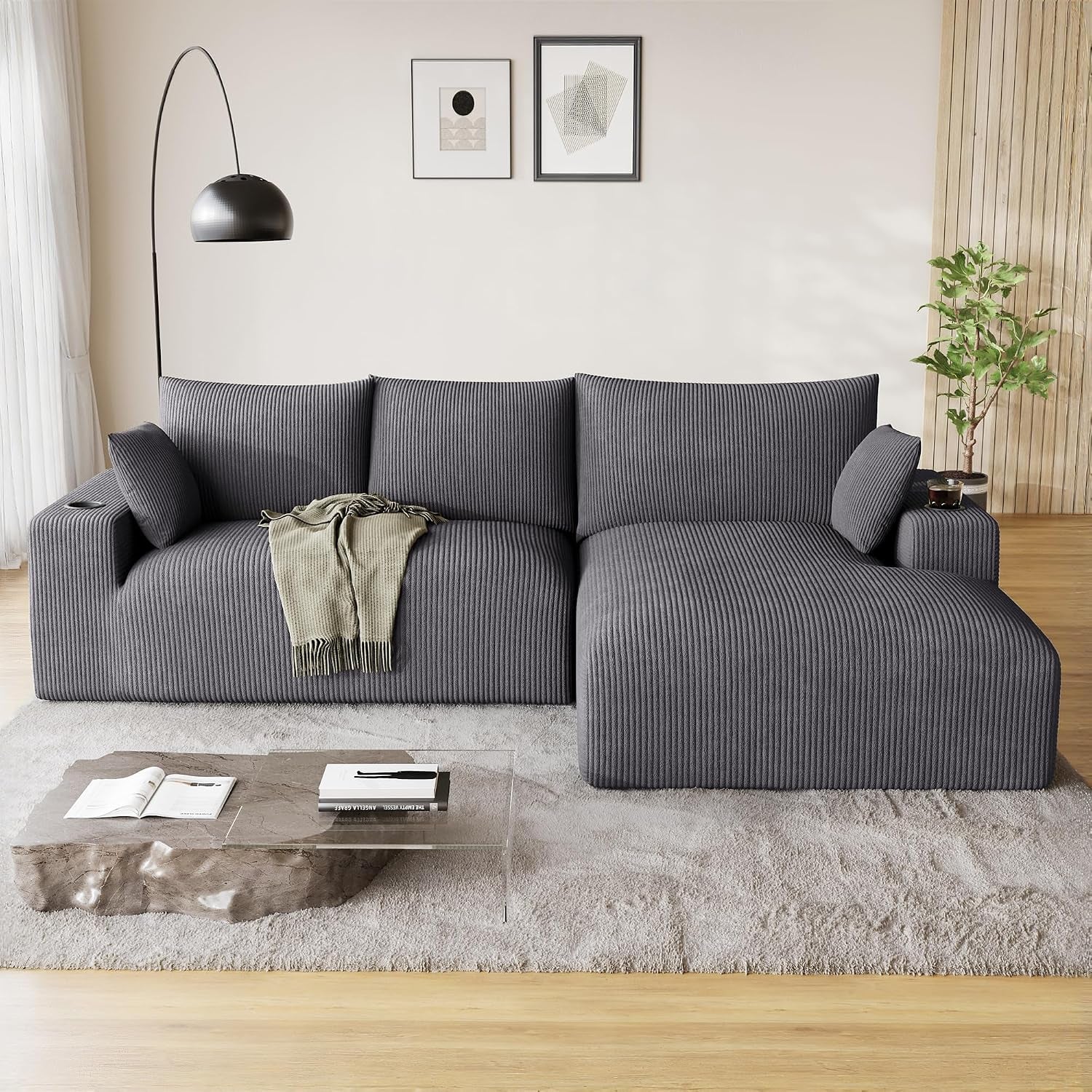 Front view of a corduroy-textured dark gray L-shaped sectional with chaise on the right in a bright living room.