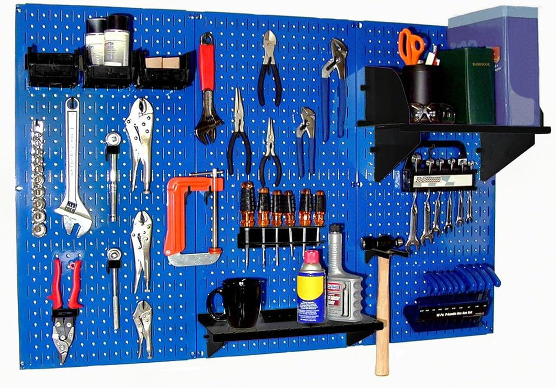 Blue pegboard mounted on wall with black shelves, various hand tools and a hammer.