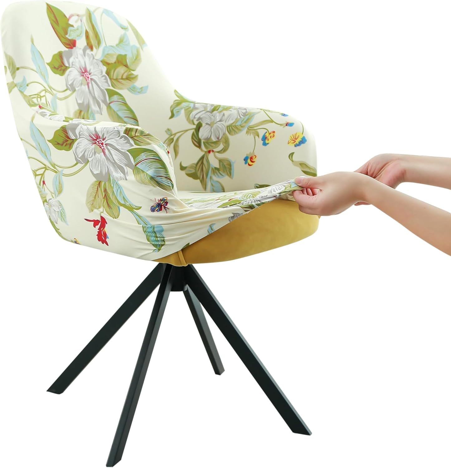 Side view of a floral patterned stretch chair cover being pulled over an armchair by two hands.