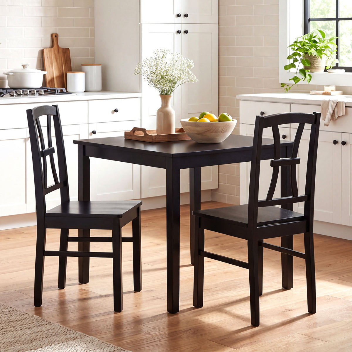 Two black cross-back chairs beside a dark dining table in a bright kitchen.