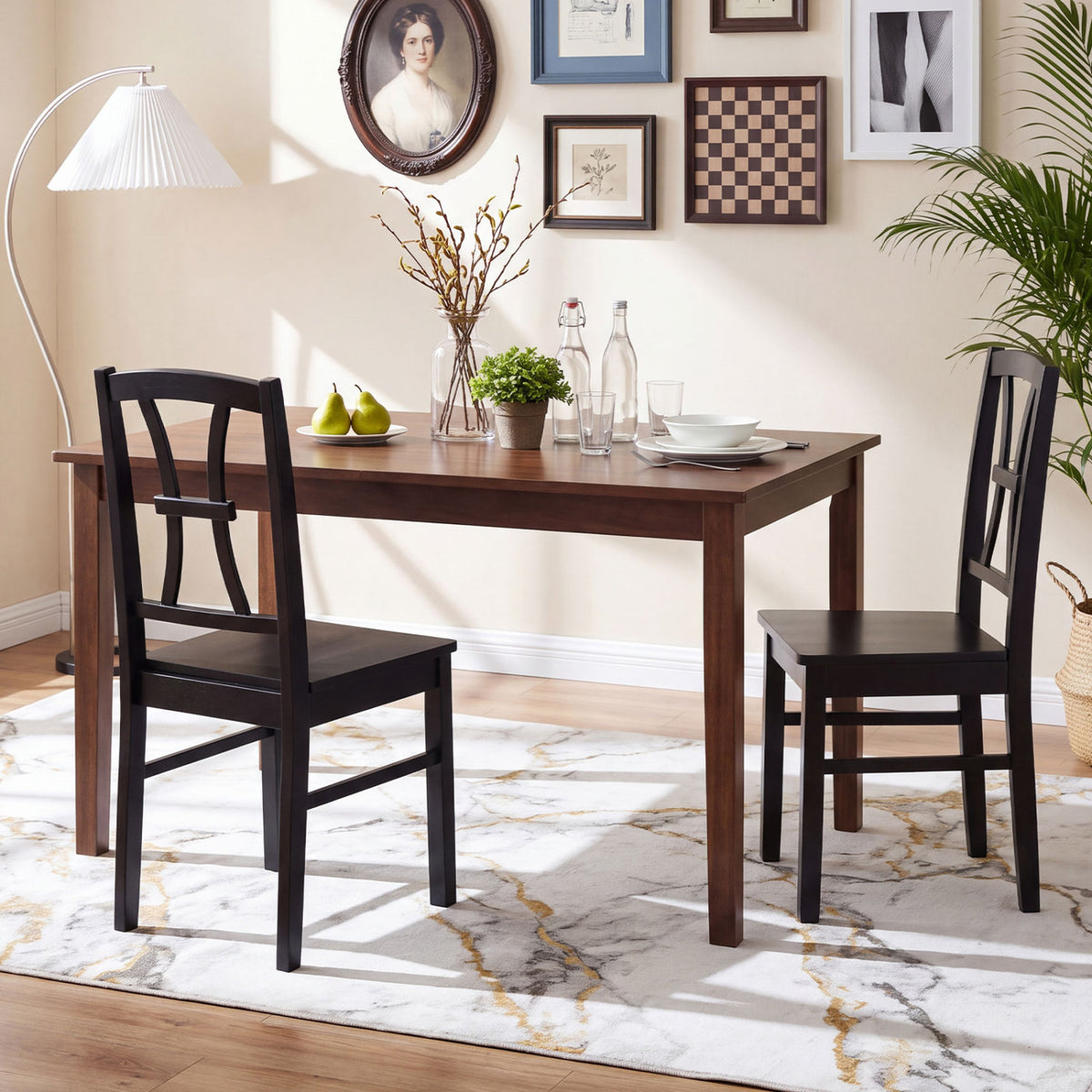 Two black cross-back chairs arranged at a wooden dining table in a decorated room.