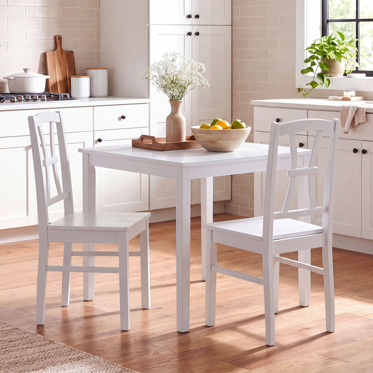 Two white crossed-back chairs beside a white dining table in a bright kitchen.