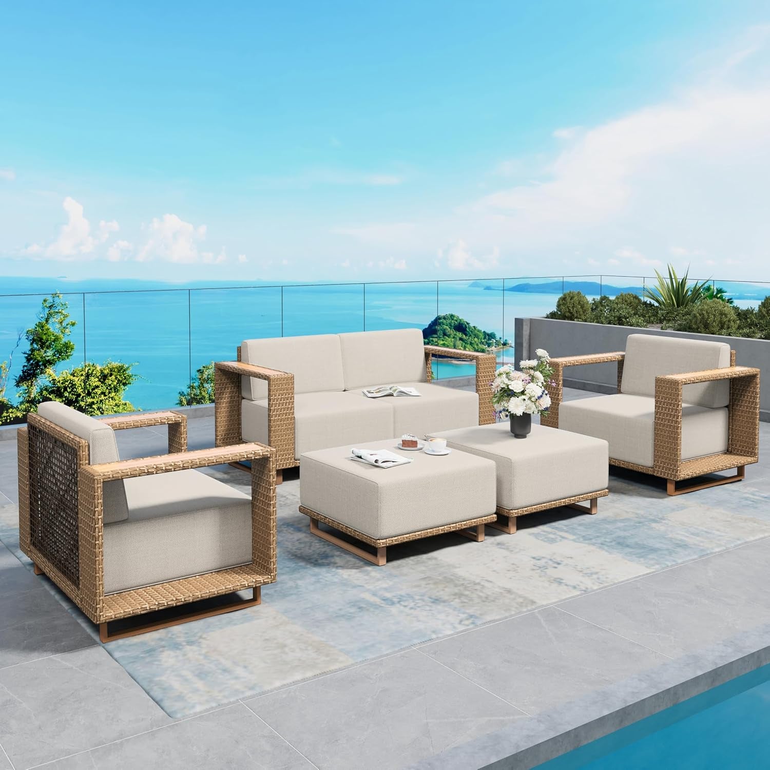 Outdoor patio set with three-seat sofa, two armchairs and two ottomans on a tiled terrace.