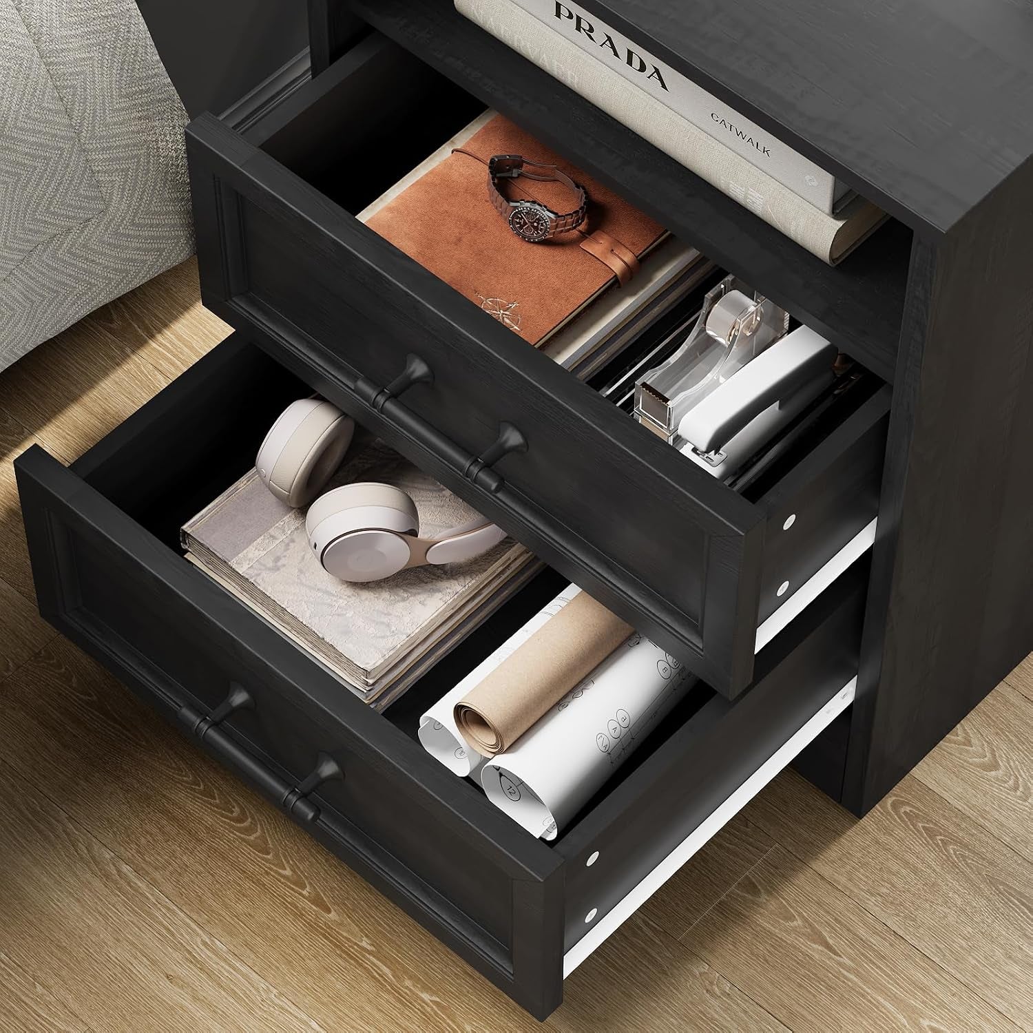 Open drawers of black nightstand filled with headphones and accessories, angled overhead view