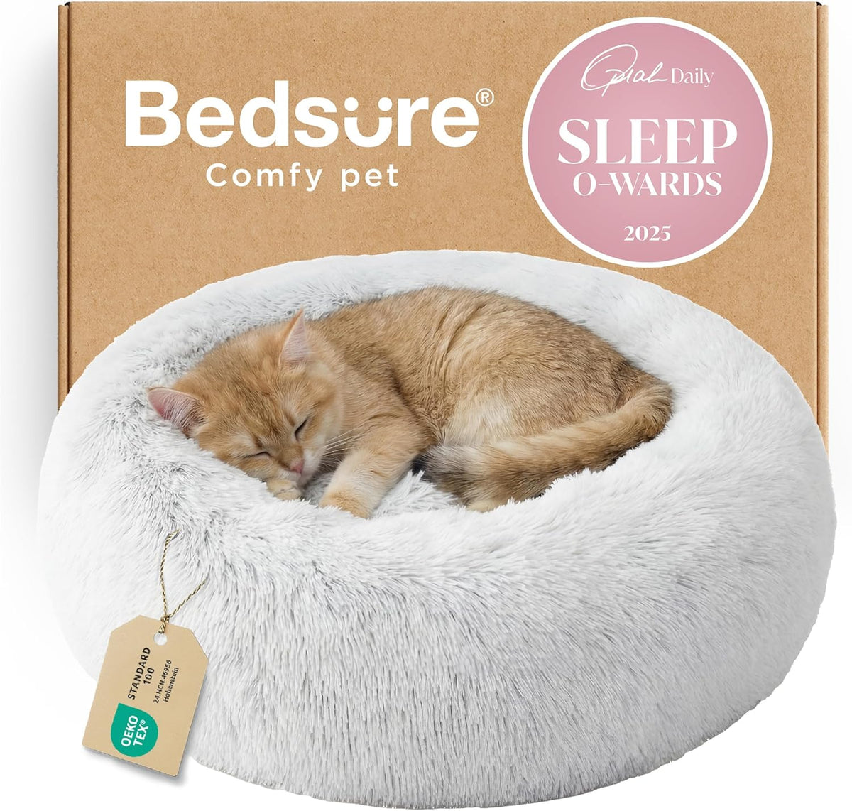 White/cream faux-fur donut pet bed with a sleeping orange kitten in front of cardboard packaging