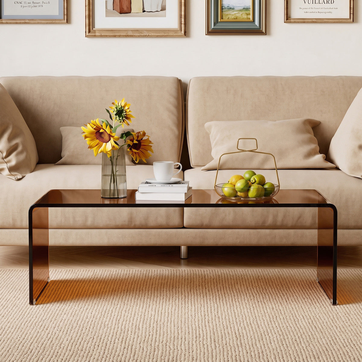 Dark brown glass coffee table in front of a beige sofa, holding flowers, a cup, and a bowl of fruit.