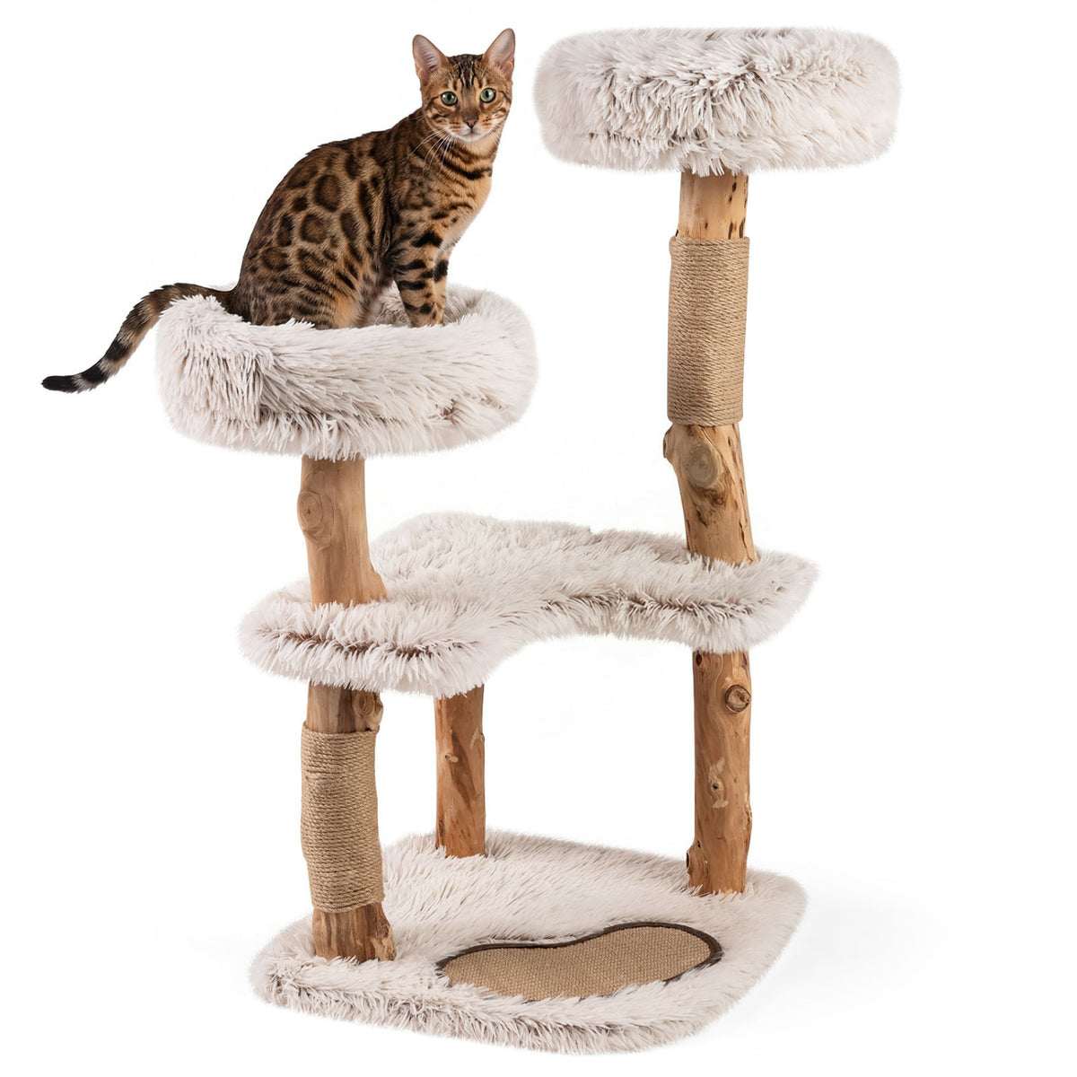 A spotted cat sits on a padded perch beside the upper platform of a white cat tree on a plain background.