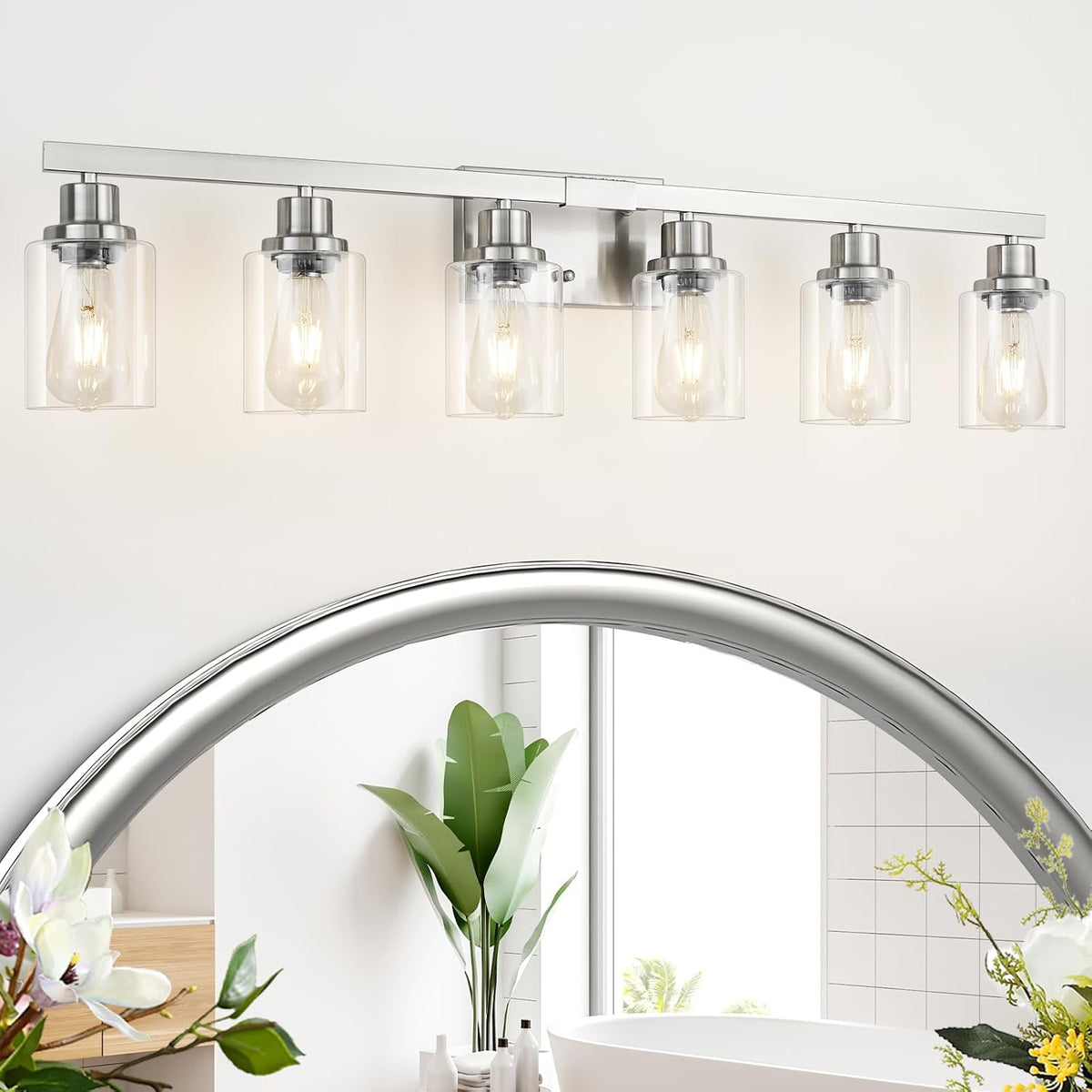 Six-light brushed nickel vanity light with clear glass shades centered over a rounded mirror.