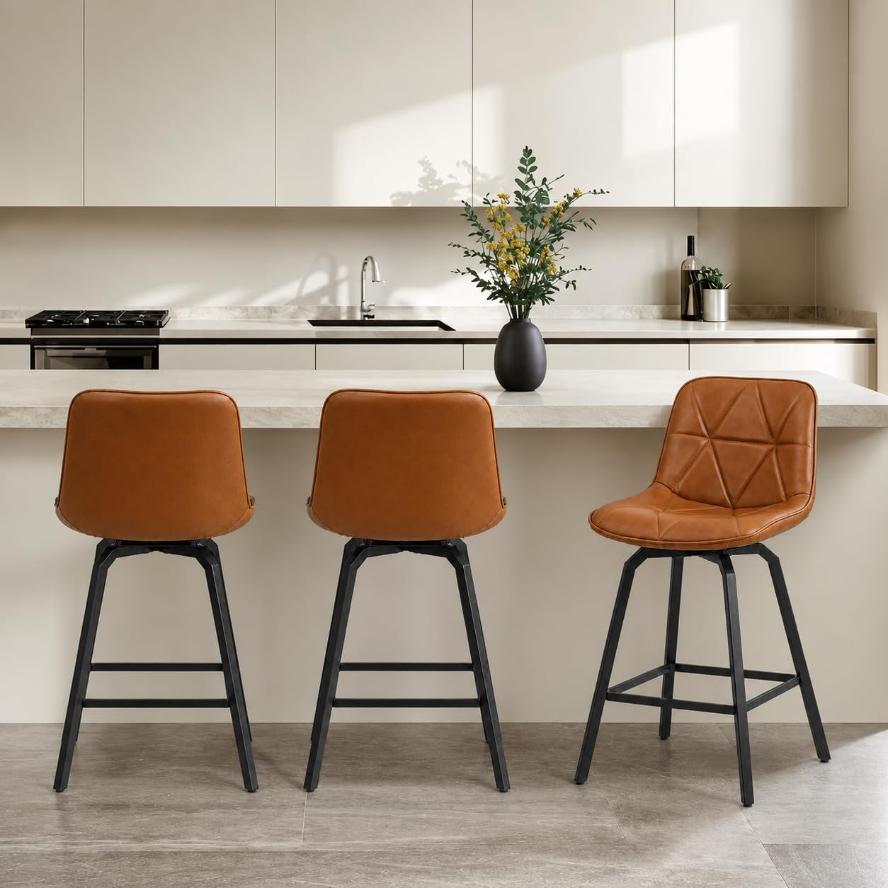 Three tan leather-look swivel stools seen from the back along a light kitchen counter.