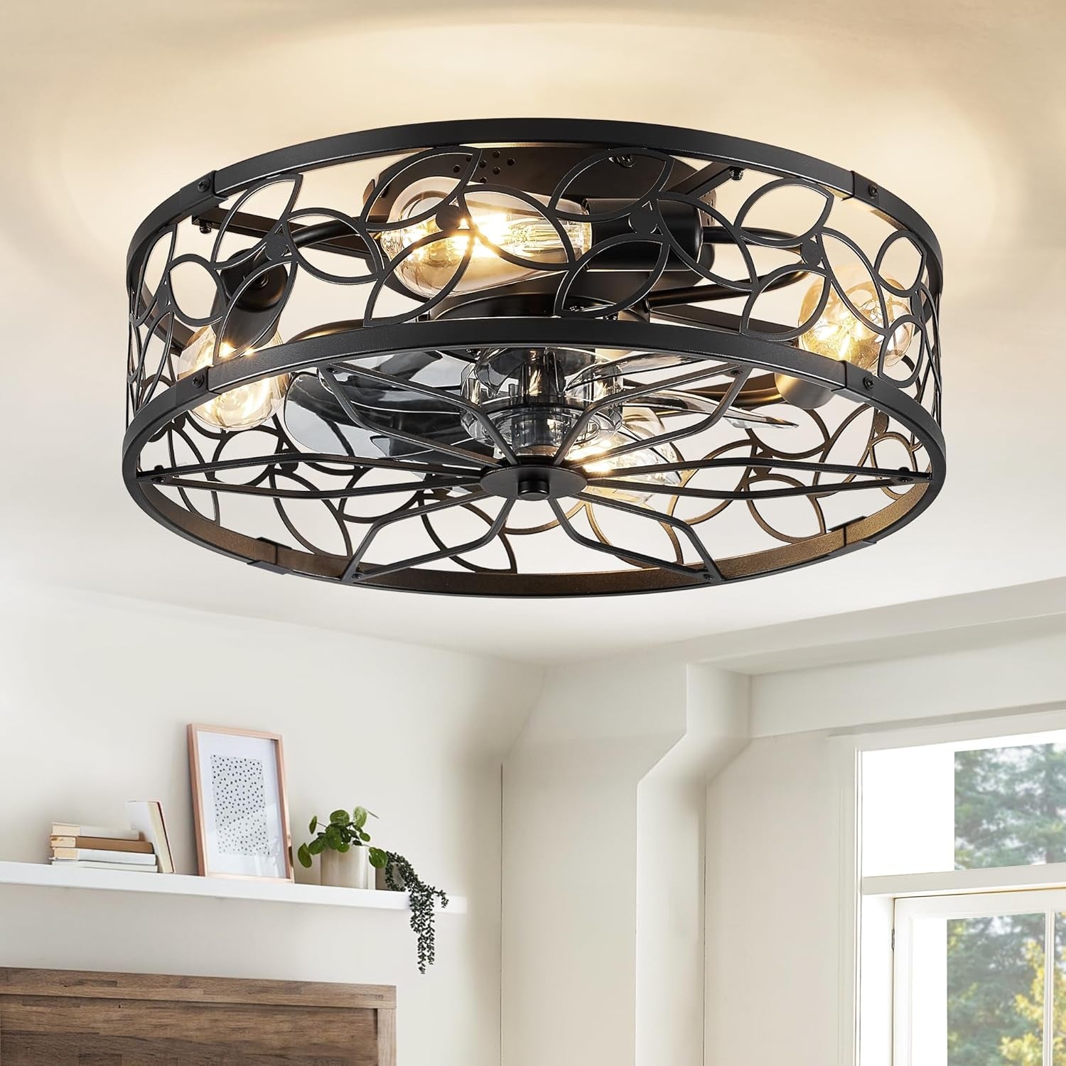 Black caged flush-mount fan with patterned metal grille and warm bulbs in a bright living space.