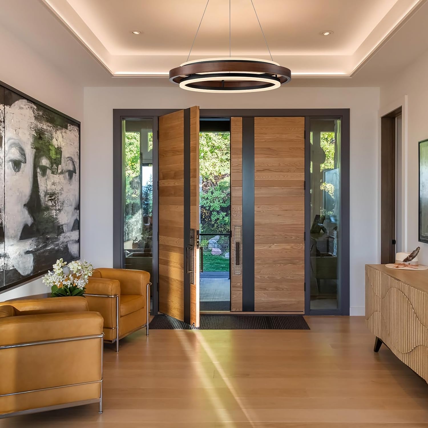 Walnut-color two-ring chandelier installed in an entryway with an open front door and seating visible