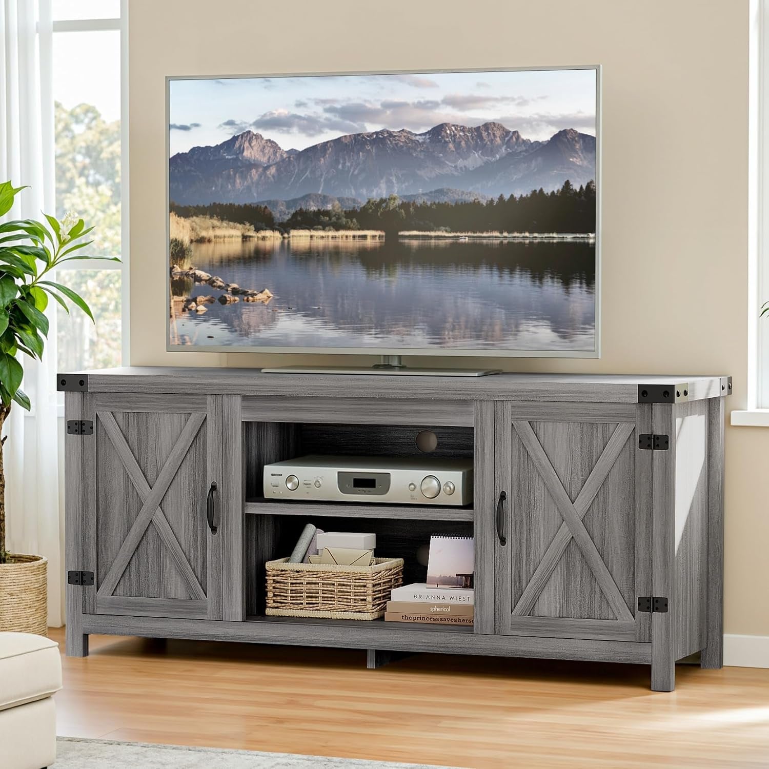 Gray-wash farmhouse TV stand with barn-style doors, a TV on top and shelves holding a stereo and basket