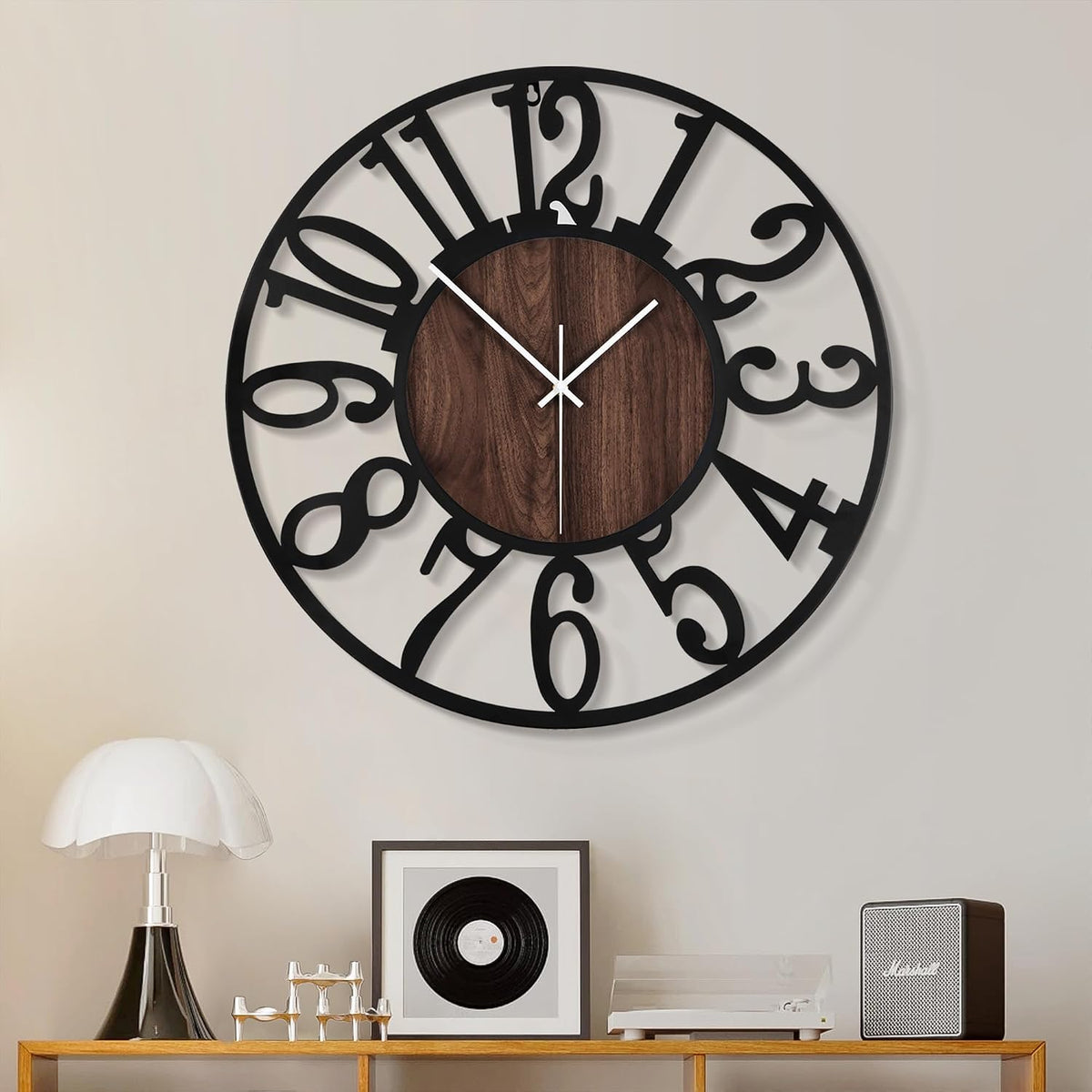 Front-facing clock with bold curving Arabic numerals and dark wood center over a tabletop scene