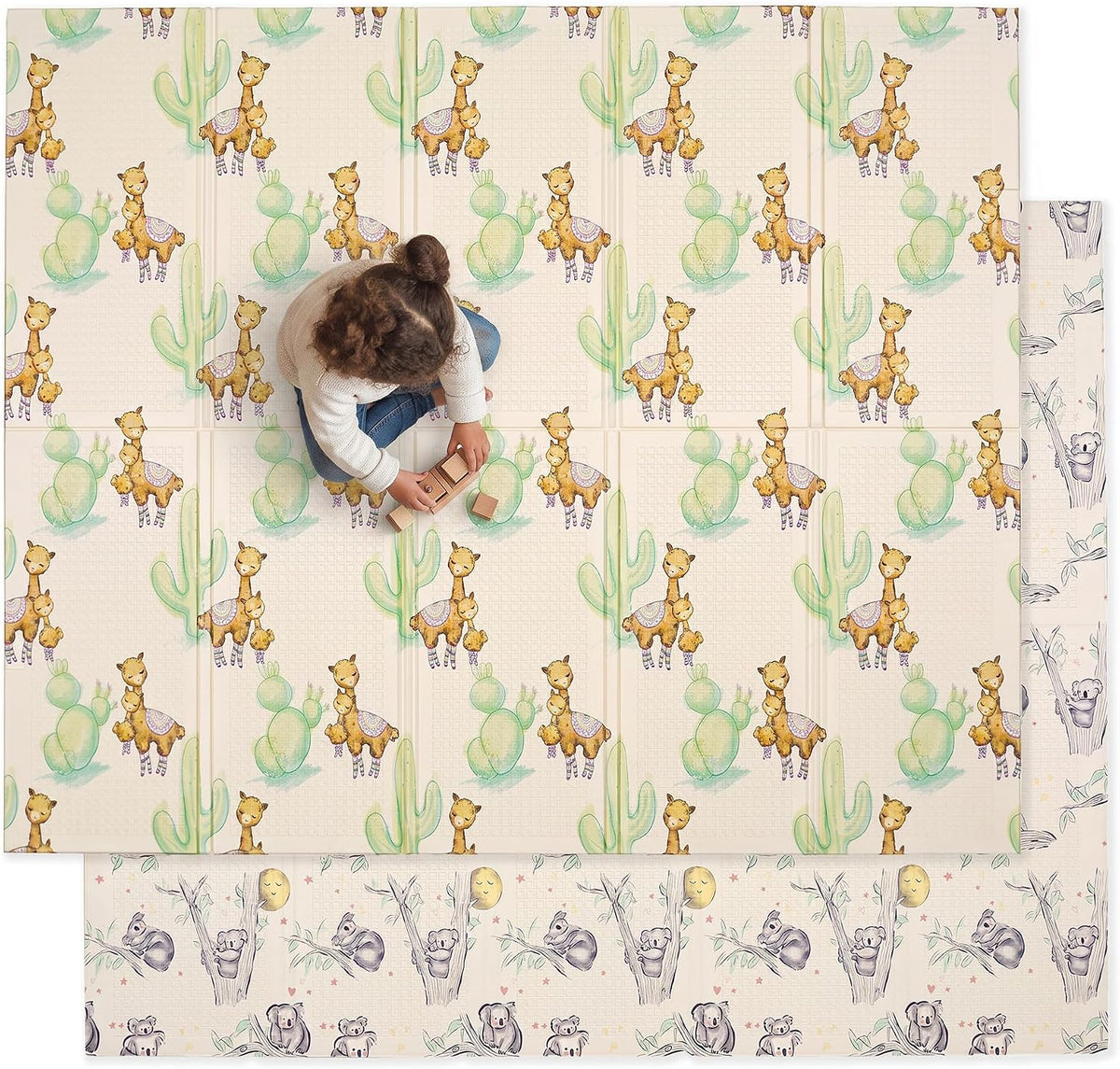 Overhead view of a toddler playing on a double-sided mat decorated with llamas and cacti