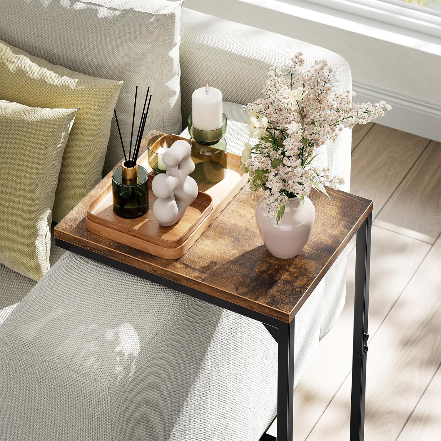 Close-up of the table's rustic brown top and black metal frame with decorative tray and vase.