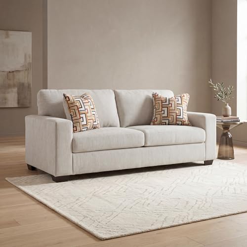 Stone chenille sofa front view in a styled living room with patterned pillows and a round side table