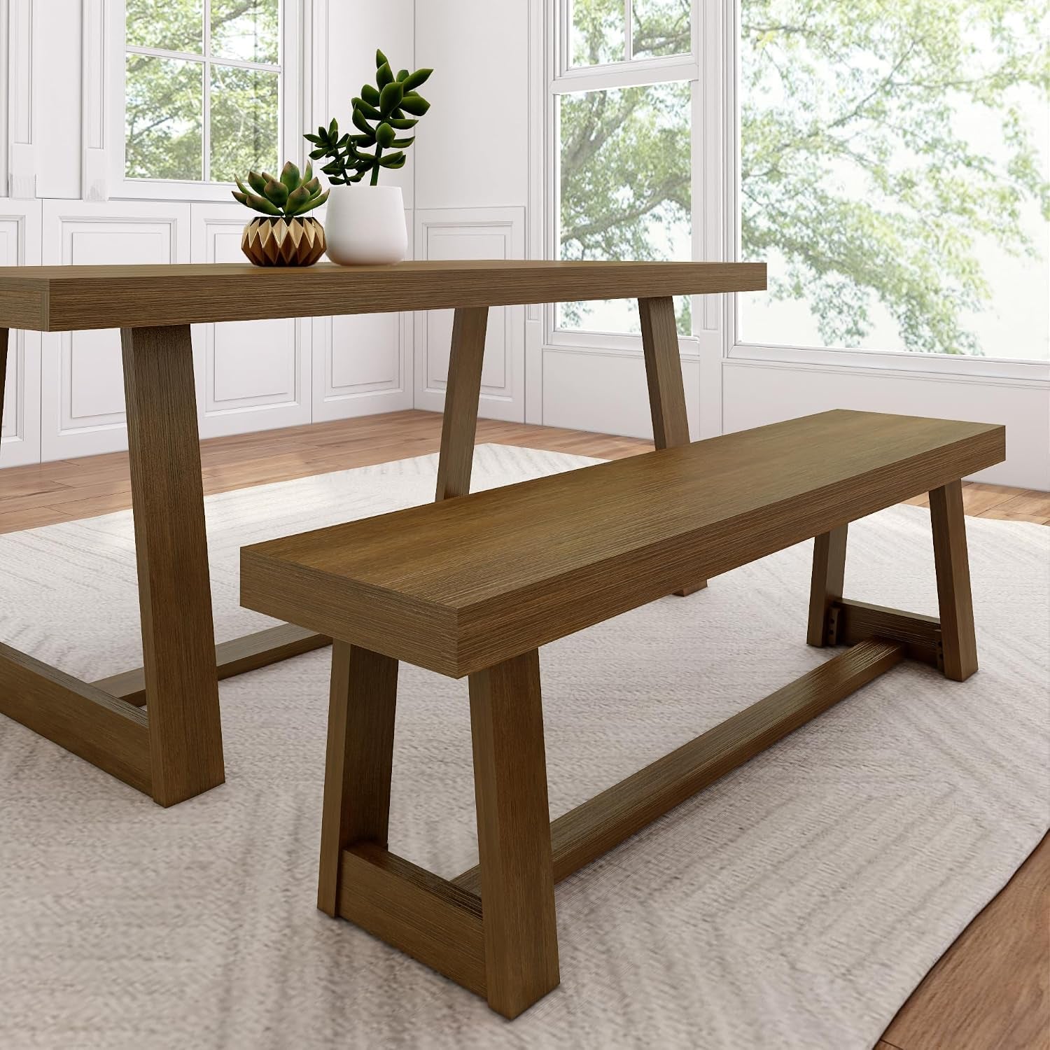 Pecan-toned dining bench and table shown close-up on a textured neutral rug with plants on the table
