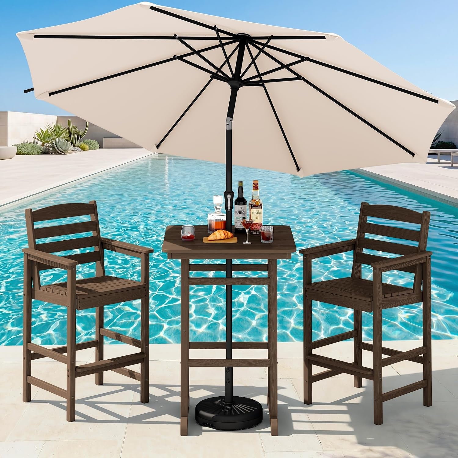 Medium brown bar chairs and square table at a pool, shaded by a wide beige patio umbrella.