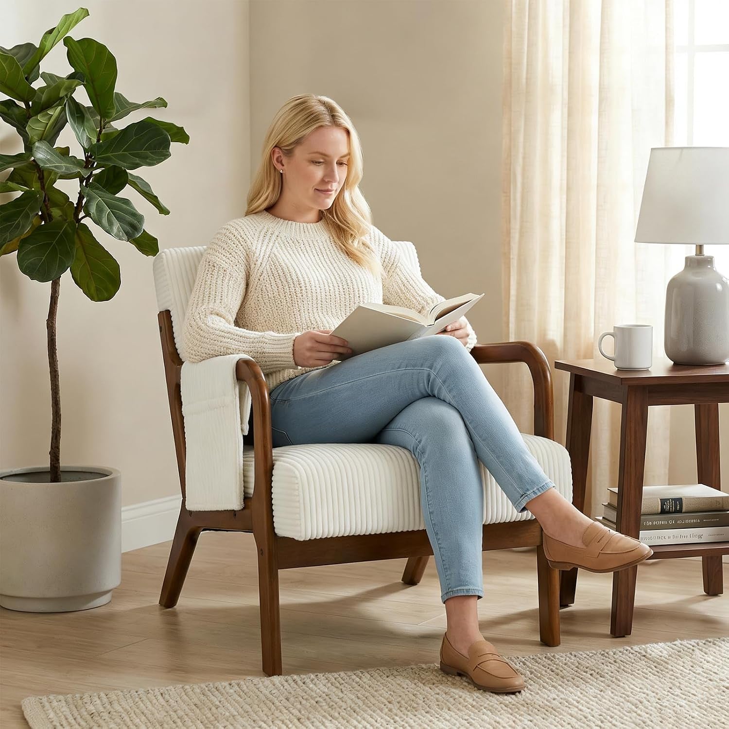 Woman reading while seated on a beige upholstered wood-frame accent chair in a bright living room.