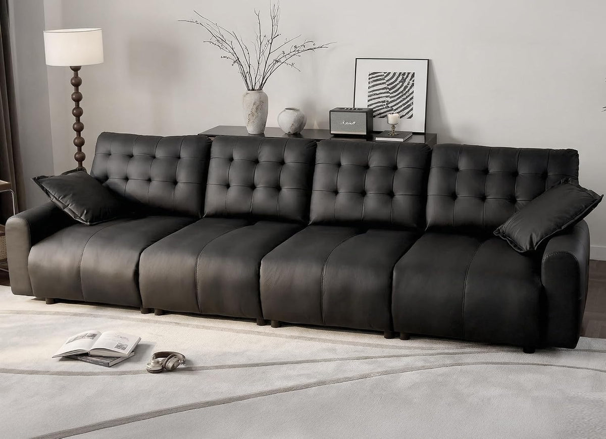 Front view of the same oversized sectional shown in black leather with tufted backs and two accent pillows.