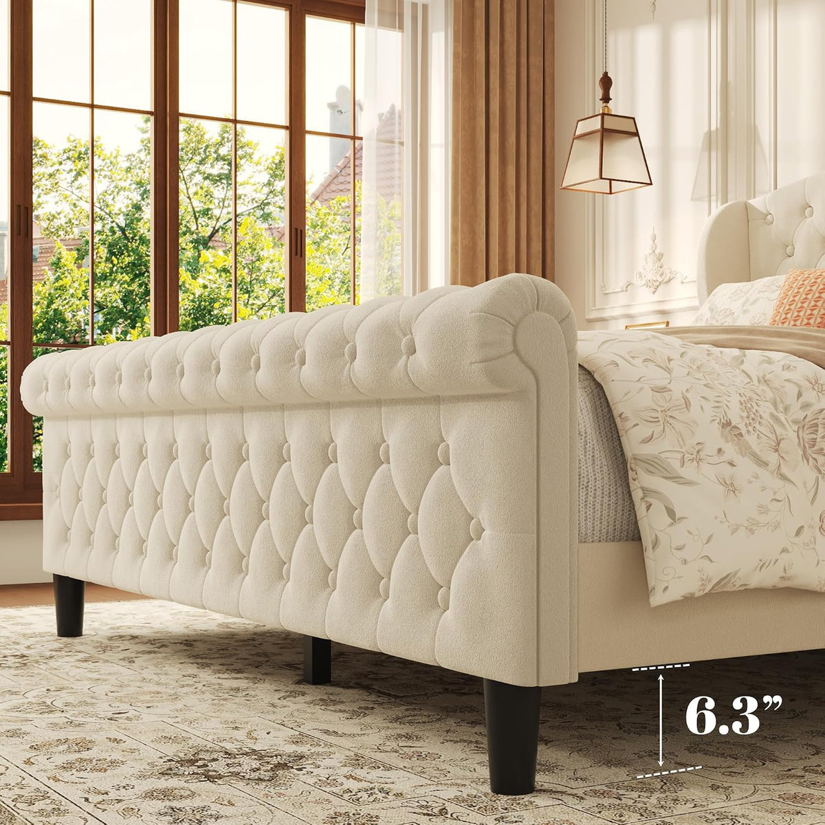 Person seated against the tufted wingback beige velvet headboard reading a magazine with pillows staged around